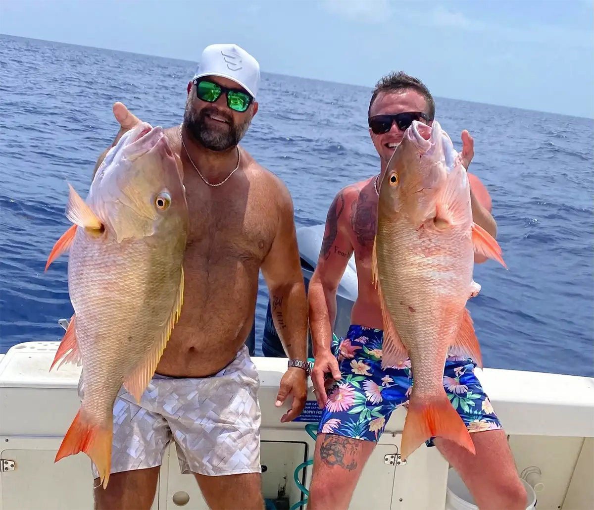 Two anglers holding mutton snapper offshore near Marathon Florida Keys