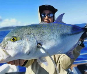 Angler holding a large blue spotted trevally on an Amami Fishing Tour in Kagoshima Japan