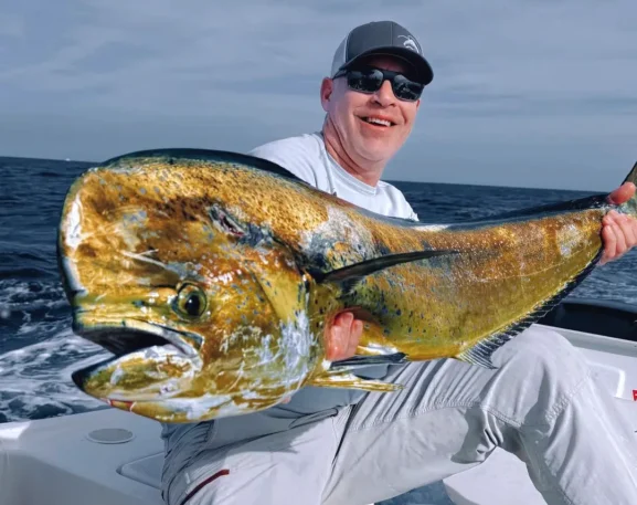 Angler holding a large dorado mahi mahi on a fishing boat near Cabo San Lucas