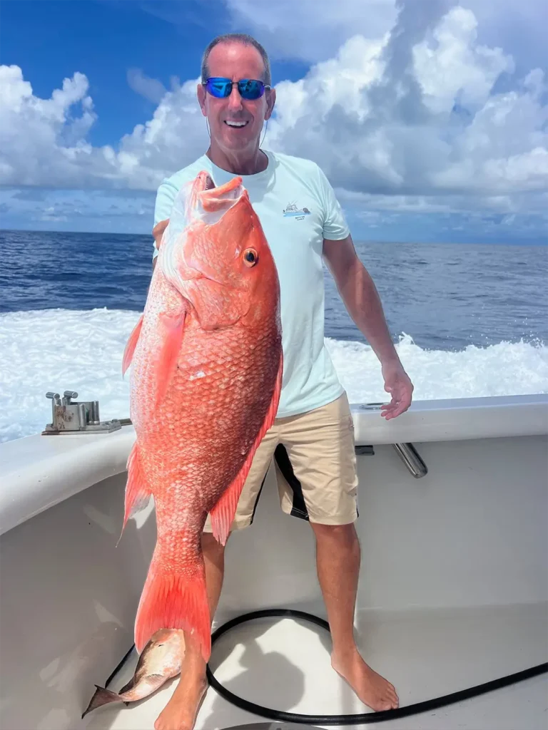 Angler holding a large red snapper on a fishing boat near Clearwater Beach, Florida