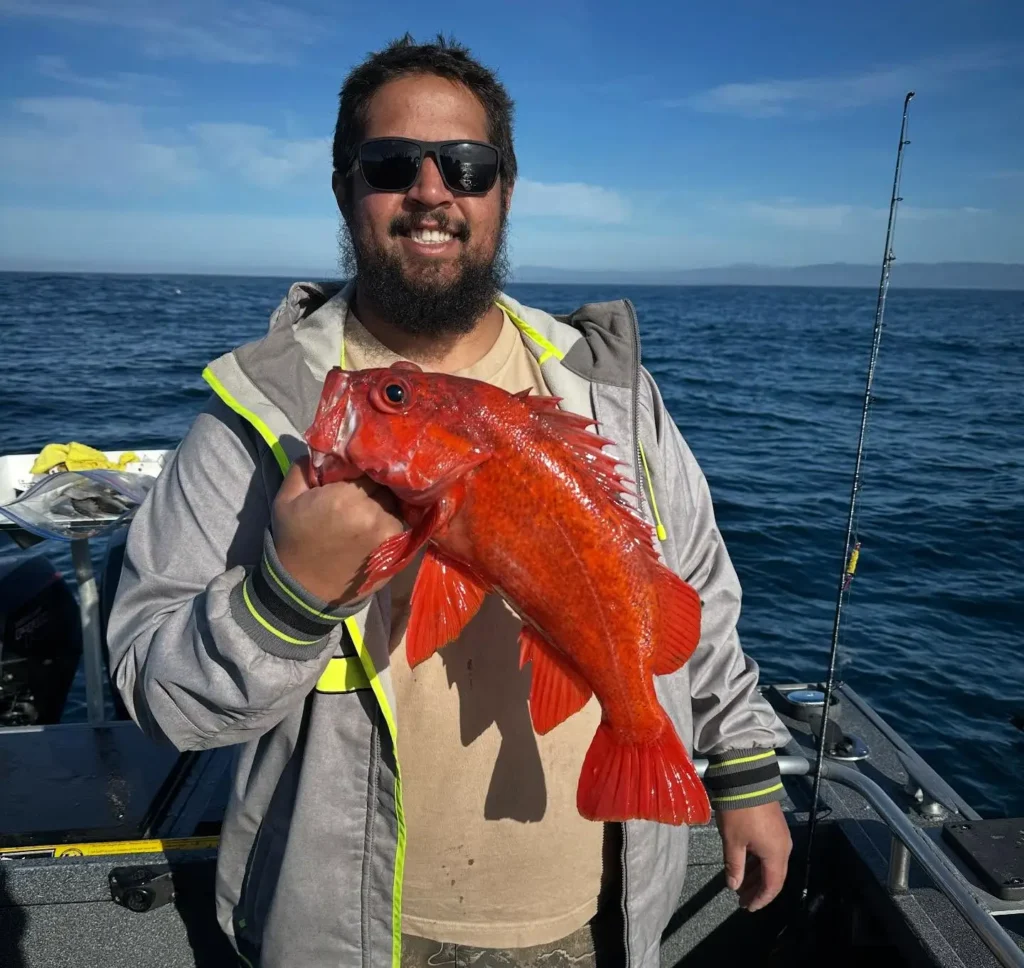 Angler smiling with a vermilion rockfish aboard Crescent City Fishing.