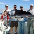 Group of anglers holding a large sailfish on a Miami offshore fishing boat