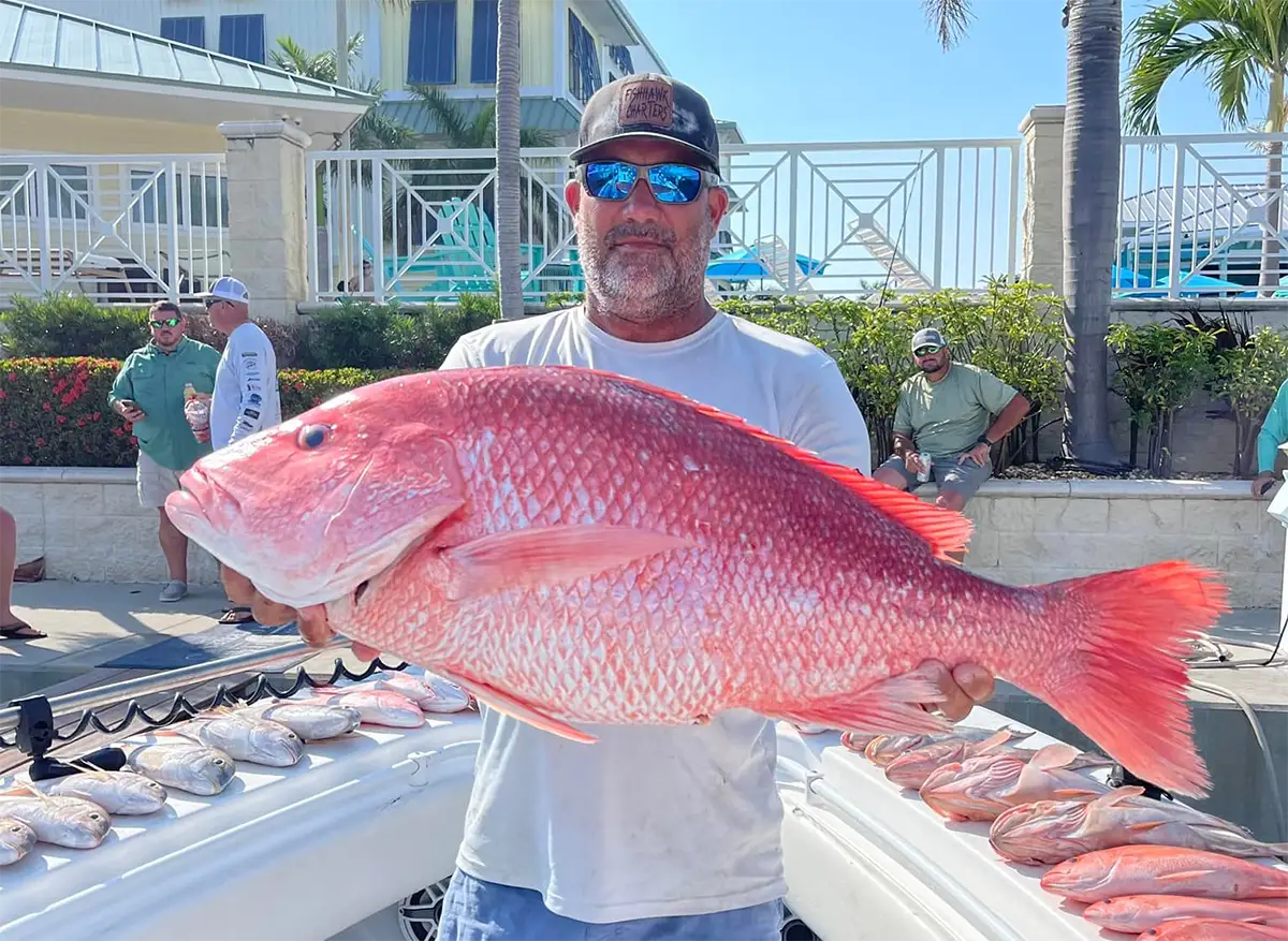 Angler holding a large red snapper at the dock with FishHawk Charters St Petersburg