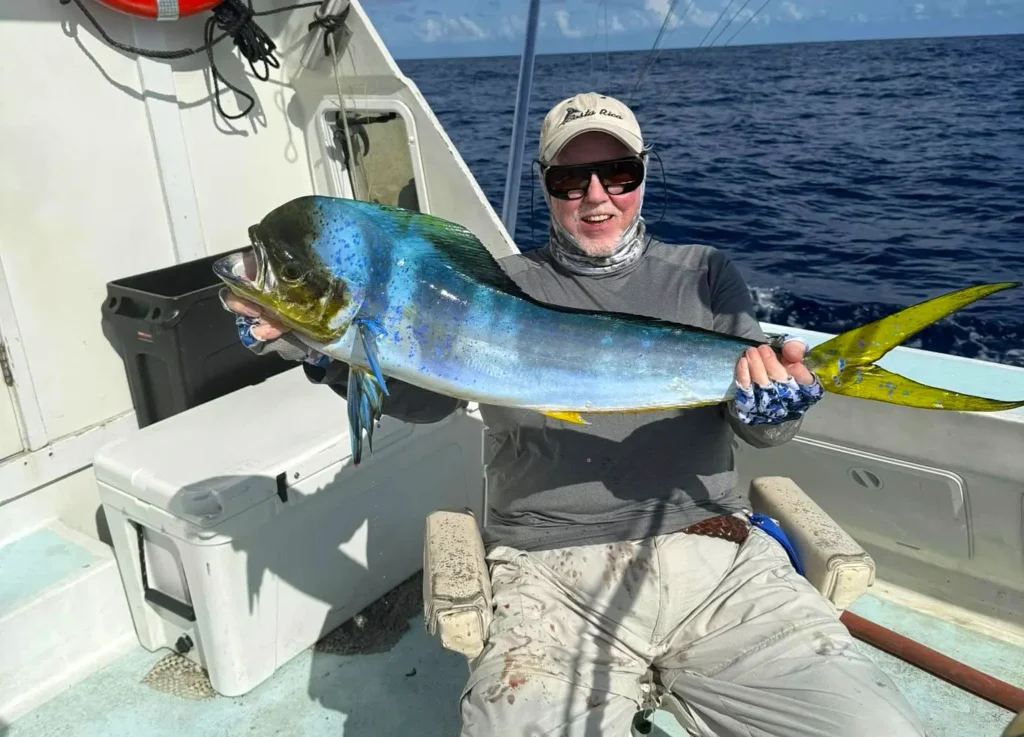 Angler holding a mahi mahi on an offshore Florida Keys fishing boat
