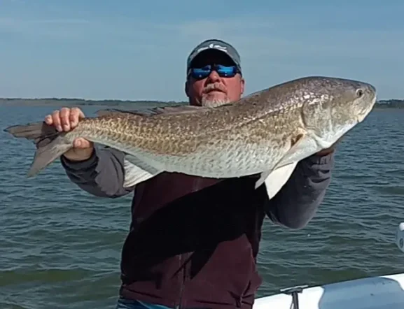 Angler holding a large redfish on the fishing boat "Freebird" near Gulf Shores Alabama