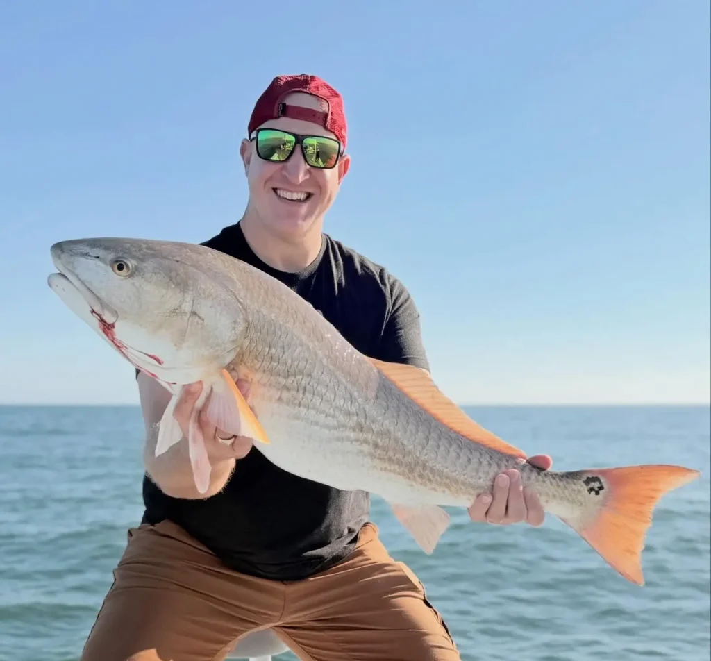 Angler holding a large redfish on a sunny November day near Hilton Head with Off the Hook Charters