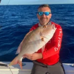 Angler in Islamorada holding a large mutton snapper on a boat