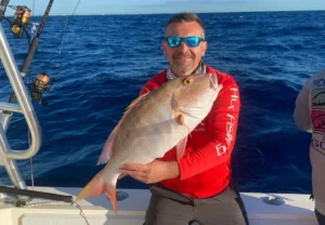 Angler in Islamorada holding a large mutton snapper on a boat