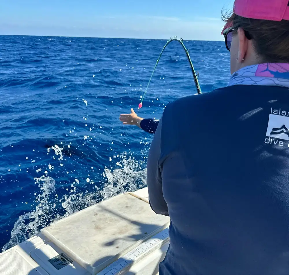 Angler fighting a fish with bent rod on offshore fishing boat near Islamorada
