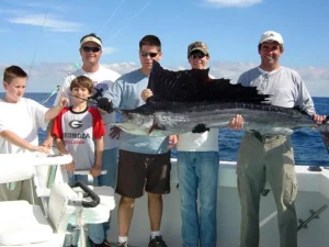 Group of anglers holding a large sailfish on a Miami offshore fishing boat