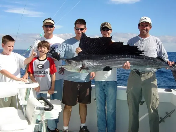 Group of anglers holding a large sailfish on a Miami offshore fishing boat