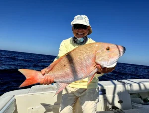 Angler holding a mutton snapper caught offshore in Marathon Florida aboard Sundance Sportfishing fishing charter