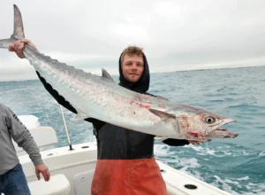 Angler in Marathon holding a large kingfish on a boat