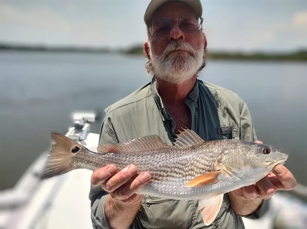 angler holding a redfish on a Savannah GA backwater fishing charter