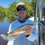Angler holding a redfish caught in Tampa Bay Florida aboard Shallow Point Charters inshore fishing charter