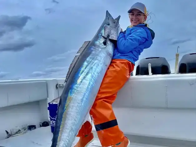 Man size wahoo being help up by an angler in Venice, LA.